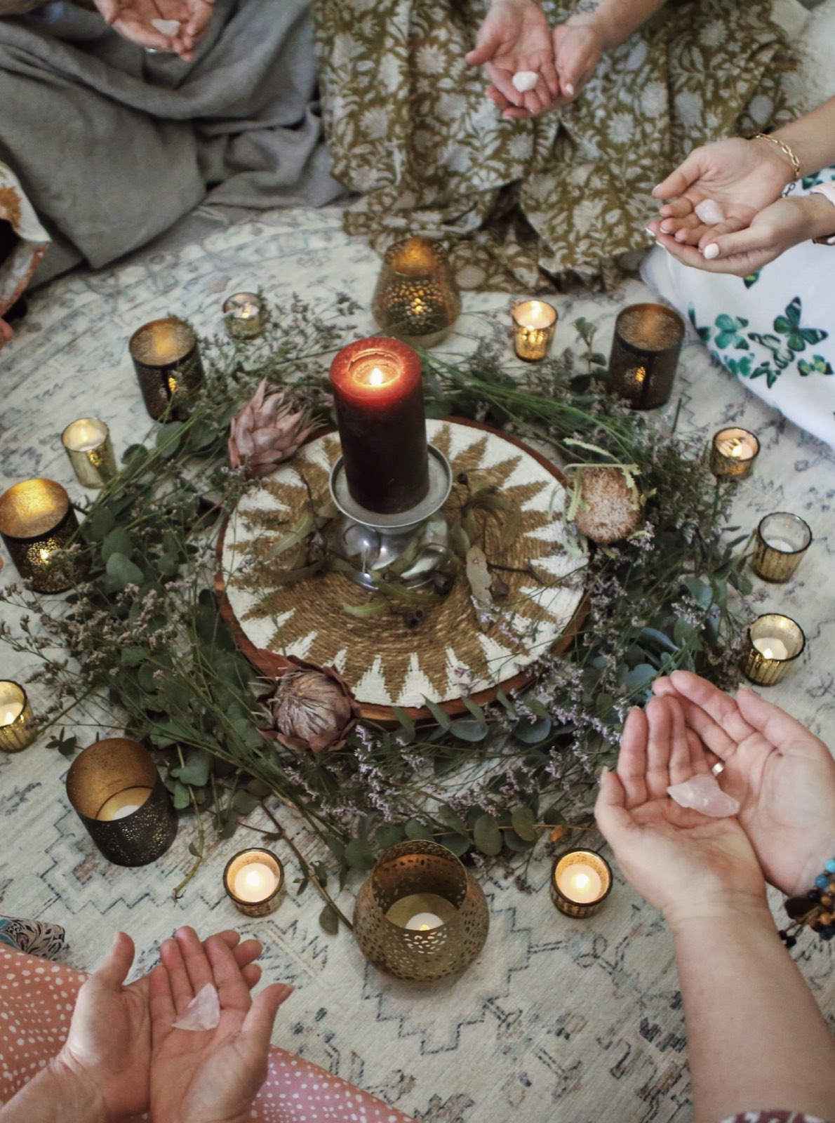 A candlelit cacao ceremony circle laid with flowers